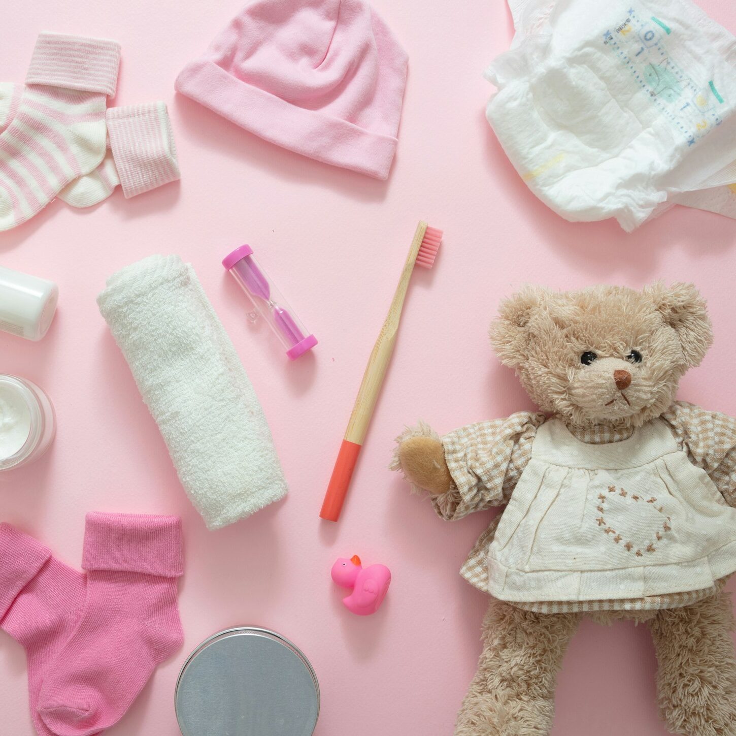 Baby bathing accesories on pink background, top view